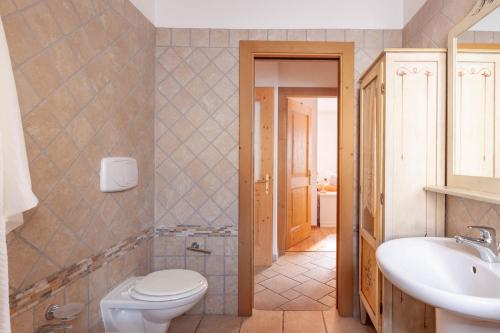 a bathroom with a toilet and a sink at The Dolomites Lodge in San Pietro di Cadore