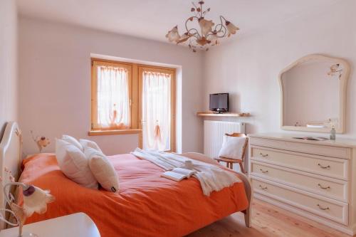 a bedroom with a bed and a dresser and a mirror at The Dolomites Lodge in San Pietro di Cadore