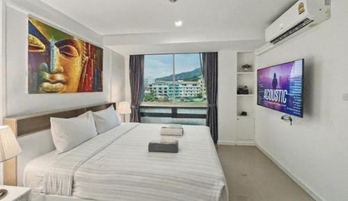 a bedroom with a large bed and a large window at Kris - Modern Spacious 2 Bedrooms Condo with Pool in Patong Beach