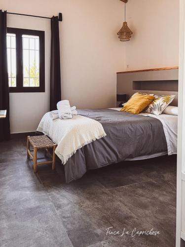 a bedroom with a large bed and a chair at Finca Caprichosa by Aracena Rural Exp in Cortelazor