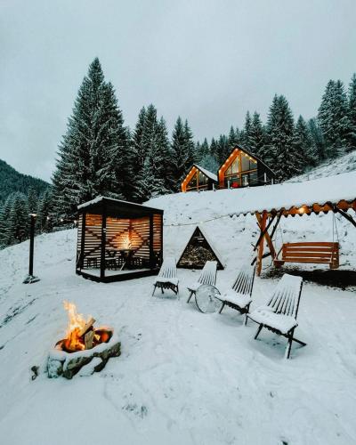 a group of chairs sitting around a fire in the snow at Котедж Royal place in Krivorovnya