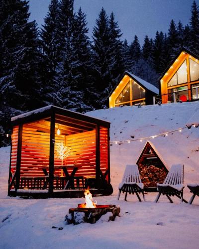 Котедж Royal place في Krivorovnya: كابينة خشب فيها نار في الثلج