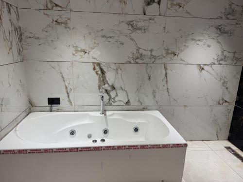 a white bath tub in a bathroom with marble walls at Hotel The Luxury Inn in Nāgaur