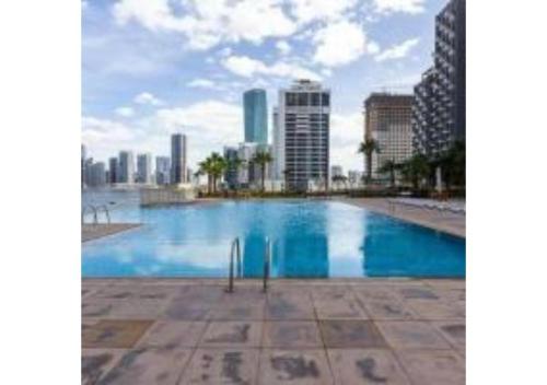 a large swimming pool with a city in the background at Yogi - 2BR Churchill - Floor 52 & Burj View in Dubai