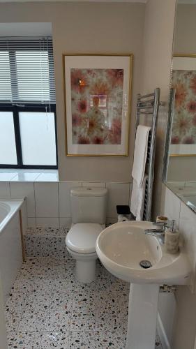 a bathroom with a white toilet and a sink at Victoria Boutique Apartment in Skipton