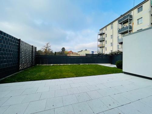 ein Innenhof mit Zaun und Rasenfläche in der Unterkunft Exklusive Haushälfte zentrumsnah in Magdeburg