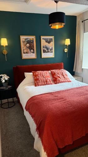 a bedroom with a bed with a red blanket at Victoria Boutique Apartment in Skipton