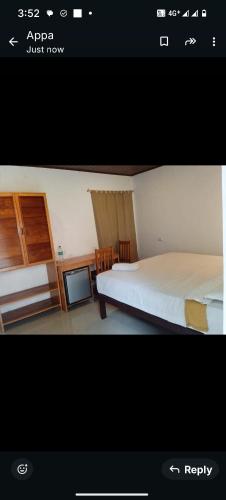 a picture of a bedroom with a bed and a tv at GP Estate Bungalow in Suryanelli