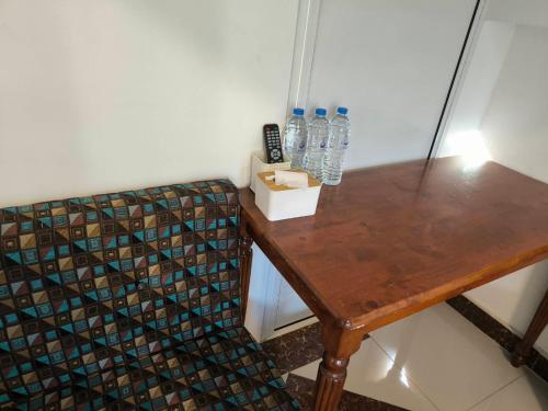 a wooden table with bottles of water on it at SB Betong GUESTHOUSE in Betong