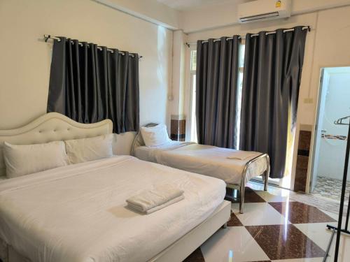 a hotel room with two beds and a window at SB Betong GUESTHOUSE in Betong