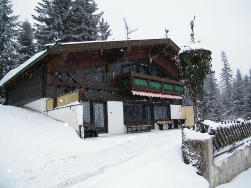een gebouw bedekt met sneeuw voor de deur bij Berghütte Inntalblick in Erlerberg