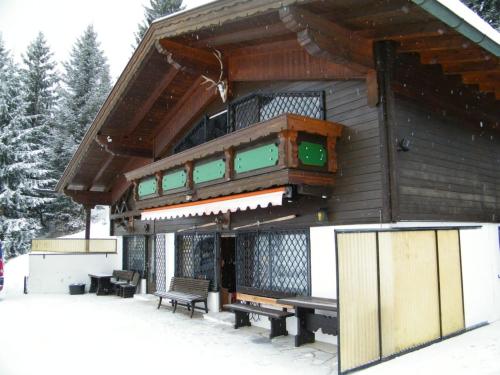 een gebouw met banken in de sneeuw bij Berghütte Inntalblick in Erlerberg