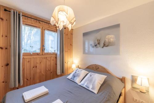 ein Schlafzimmer mit einem Bett mit zwei Kissen und einem Fenster in der Unterkunft Samoëns à Pied – Appt 4 pers in Samoëns