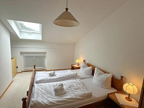 een slaapkamer met twee bedden en een raam bij Gschwendtnerhof App17 Blum in Aschau im Chiemgau