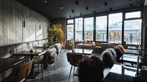 a restaurant with tables and chairs and windows at Hotel Leifur Eiriksson in Reykjavík