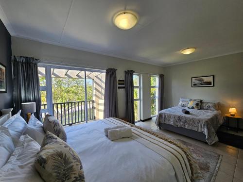 Un dormitorio con una cama grande y un balcón. en Spacious Family 2-Bedroom Apartment, en Port Alfred