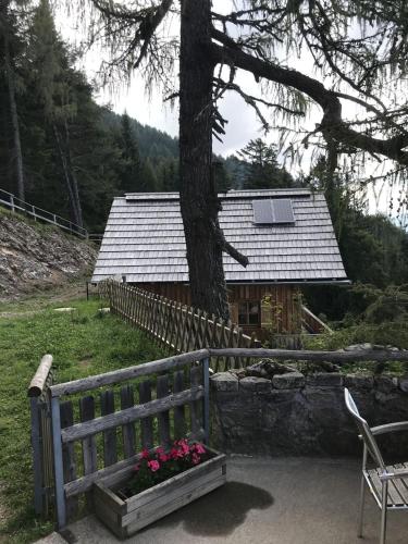 a house with a fence and a bench and flowers at Lärchenhütte in Jadersdorf