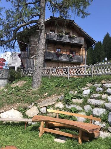 a wooden bench sitting in front of a house at Lärchenhütte in Jadersdorf