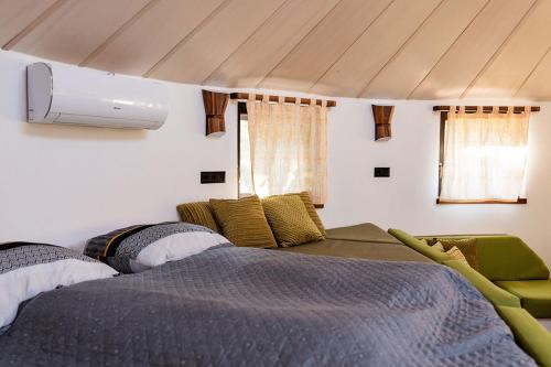 un dormitorio con una cama y un sofá en Farkaskútvölgy, en Felsőtold