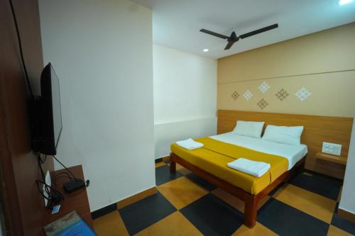 迈索尔Nandan Residency的有一张床和一台电视的房间