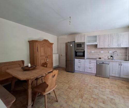 a kitchen with white cabinets and a wooden table at Escapade à Éguzon Maison 3 chambres in Éguzon-Chantôme