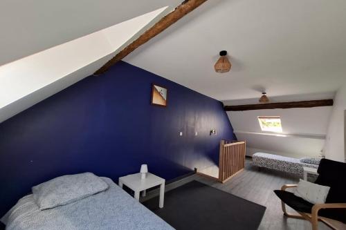 a bedroom with a blue accent wall and a bed at Escapade à Éguzon Maison 3 chambres in Éguzon-Chantôme