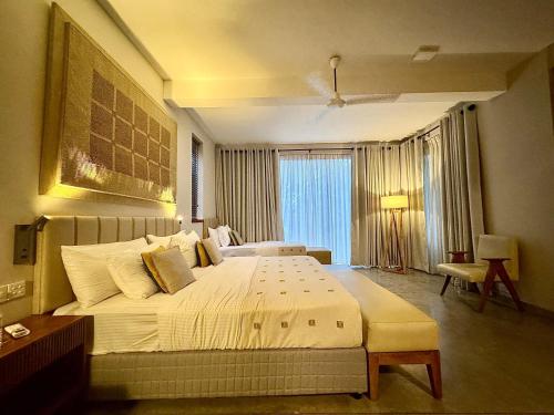 a bedroom with a large bed and a large window at Palm Paradise Cabanas & Villas Beach Resort in Tangalle