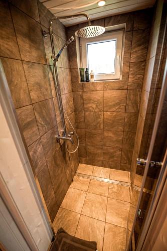 a bathroom with a shower stall with a window at HOLIDAY CABIN 'CRANE' with a private hot-tub and sauna extra fee in Avotkalni