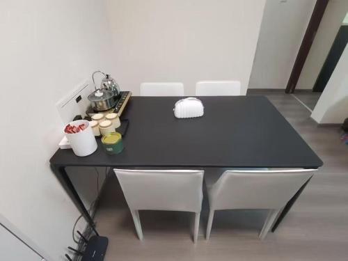 ein schwarzer Tisch mit weißen Stühlen in einem Raum in der Unterkunft Shoucheng international 2104 in Peking