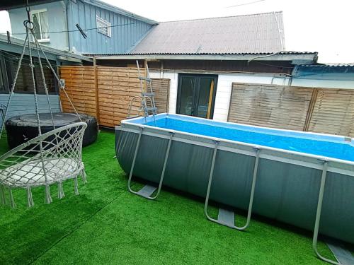 a swimming pool with a swing and a chair at kaz'manou in Saint-Benoît