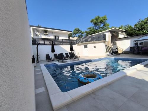 una piscina con una zattera nel mezzo di una casa di Apartmani Evica - App 1 a Crikvenica