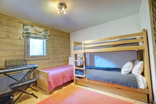 a bedroom with two bunk beds and a desk at Hameaux du glaciers in Les Houches
