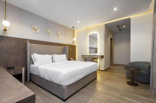 a hotel room with a large bed and a chair at CheckInn Garki, Abuja in Abuja