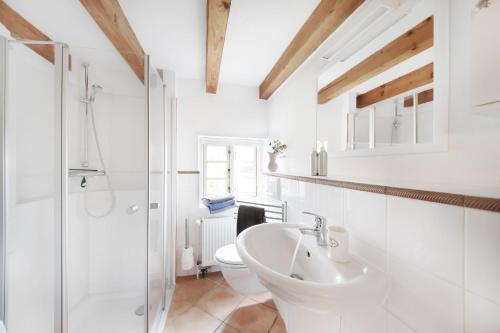 a white bathroom with a sink and a toilet at Kembser Cottage - Ostholstein - NEU! in Behrensdorf