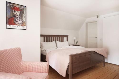 a white bedroom with a bed and a chair at Kembser Cottage - Ostholstein - NEU! in Behrensdorf