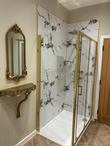 een badkamer met een douche en een spiegel bij Calsie Cottage, Clatt in Kirktown of Clatt