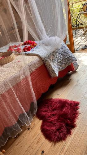 a bed sitting on a wooden floor next to a rug at Cabane & Dîner Gourmet Inclus in Barjols