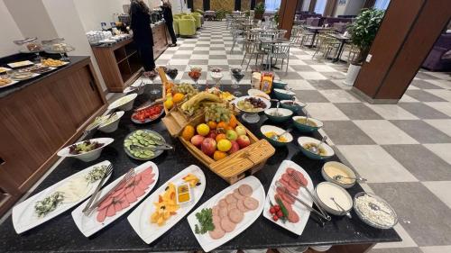 Una mesa larga con muchos platos de comida encima. en SUVON Hotel, en Stantsiya Kyzyl-Tukumachi