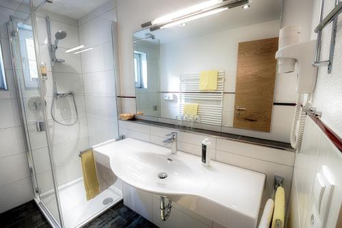 ein weißes Badezimmer mit Waschbecken und Dusche in der Unterkunft Appartement Désirée inkl der SUPER SOMMER CARD im SOMMER 2025 in Serfaus