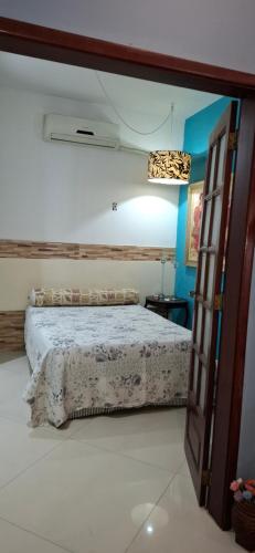 a bedroom with a bed and a open door at Casa de Lorna 2 in Rio de Janeiro