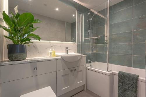 a bathroom with a sink and a shower and a tub at Rigg & Rest Apartment - Bowness in Bowness-on-Windermere