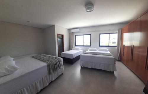 Una habitación de hotel con dos camas y dos ventanas. en Casa de férias Mirante Casa mar, en Prado