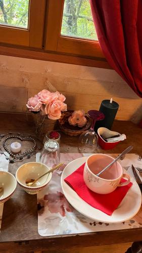 een tafel met borden, keukengerei en bloemen erop bij Cabane & Dîner Gourmet Inclus in Barjols