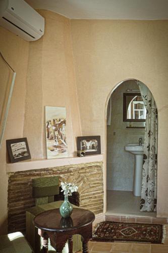 a bathroom with a sink and a table with a vase at Auberge Ayam Atlas- pool 10mn away in Ourika