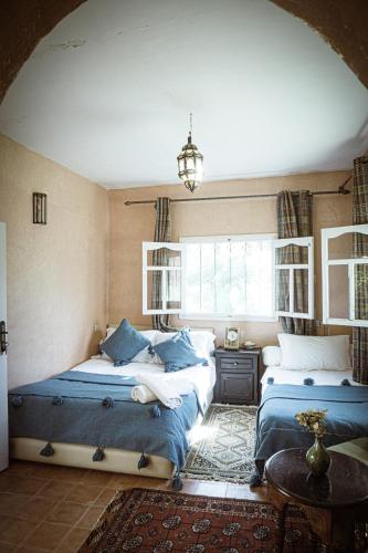 a bedroom with two beds and a chandelier at Auberge Ayam Atlas- pool 10mn away in Ourika