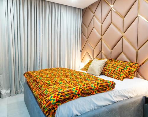 een slaapkamer met een groot bed met een kleurrijke sprei bij 1 bedroom luxury apartment, Pent unit in Accra