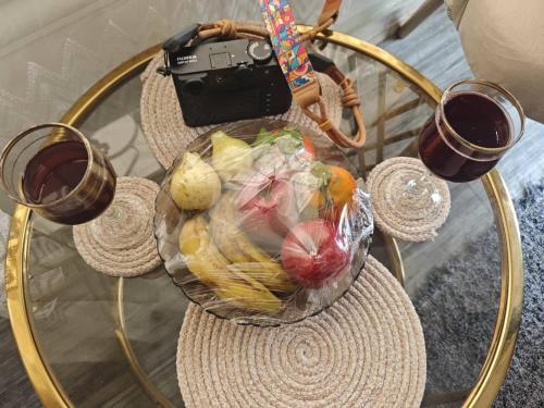 a glass table with a basket of vegetables and two glasses of wine at Wonji house in Abu Simbel
