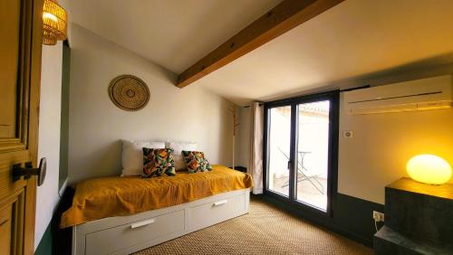een slaapkamer met een bed en een deur naar een balkon bij Townhouse with rooftop in Pernes-les-Fontaines