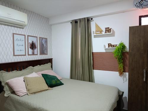 a bedroom with a bed with white sheets and pillows at Flat 402 Centro Porto Galinhas in Porto De Galinhas