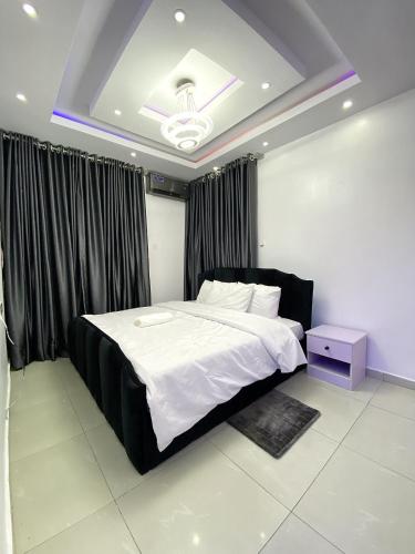 Un dormitorio con una cama grande con cabecero negro. en Fola Homes, en Suru Lere